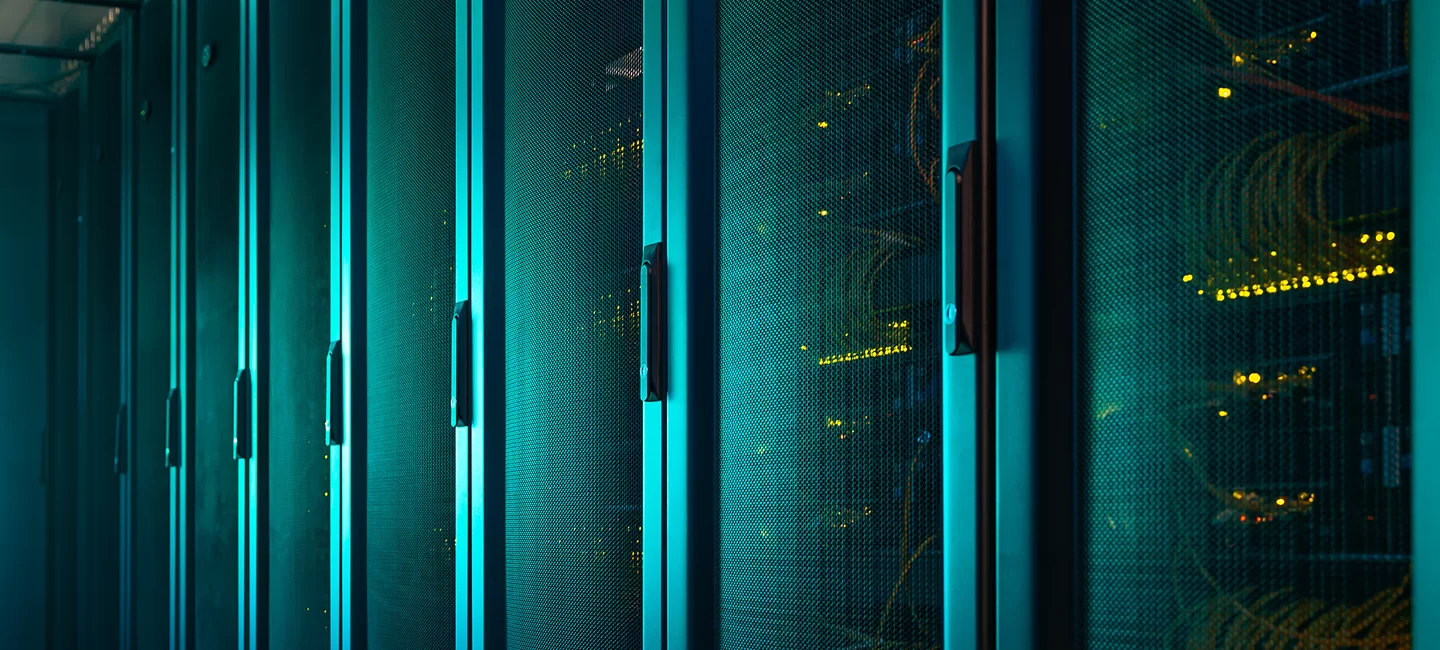 Rows of illuminated server racks in a data center, highlighting high-performance computing infrastructure.