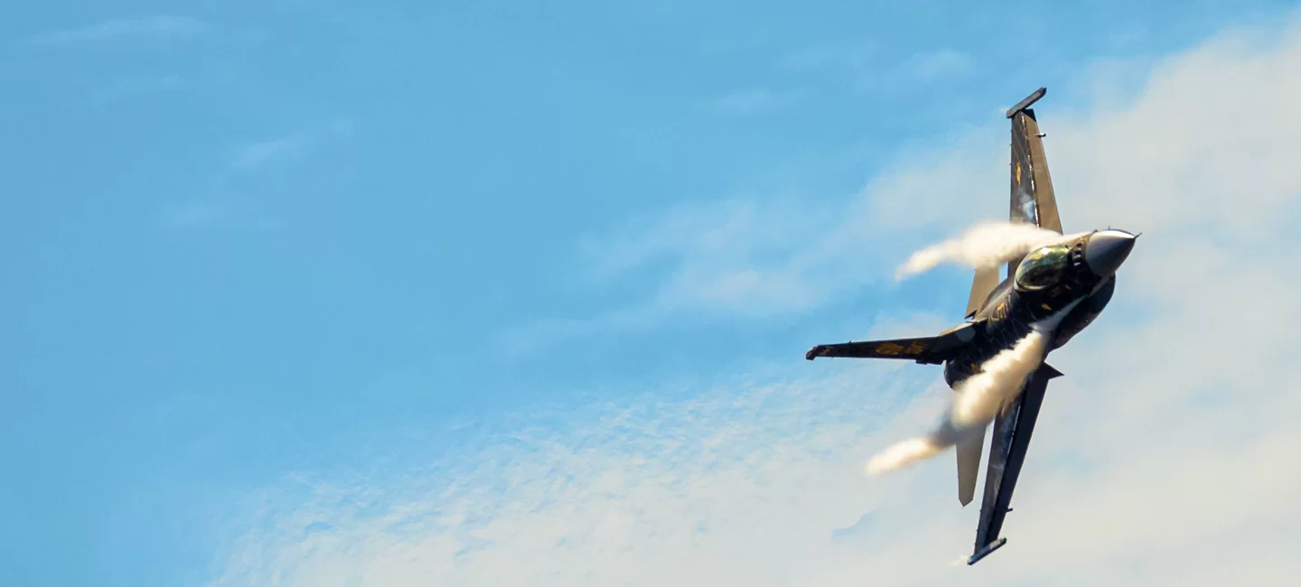 A fighter jet in flight against a clear blue sky, showcasing aerospace technology.