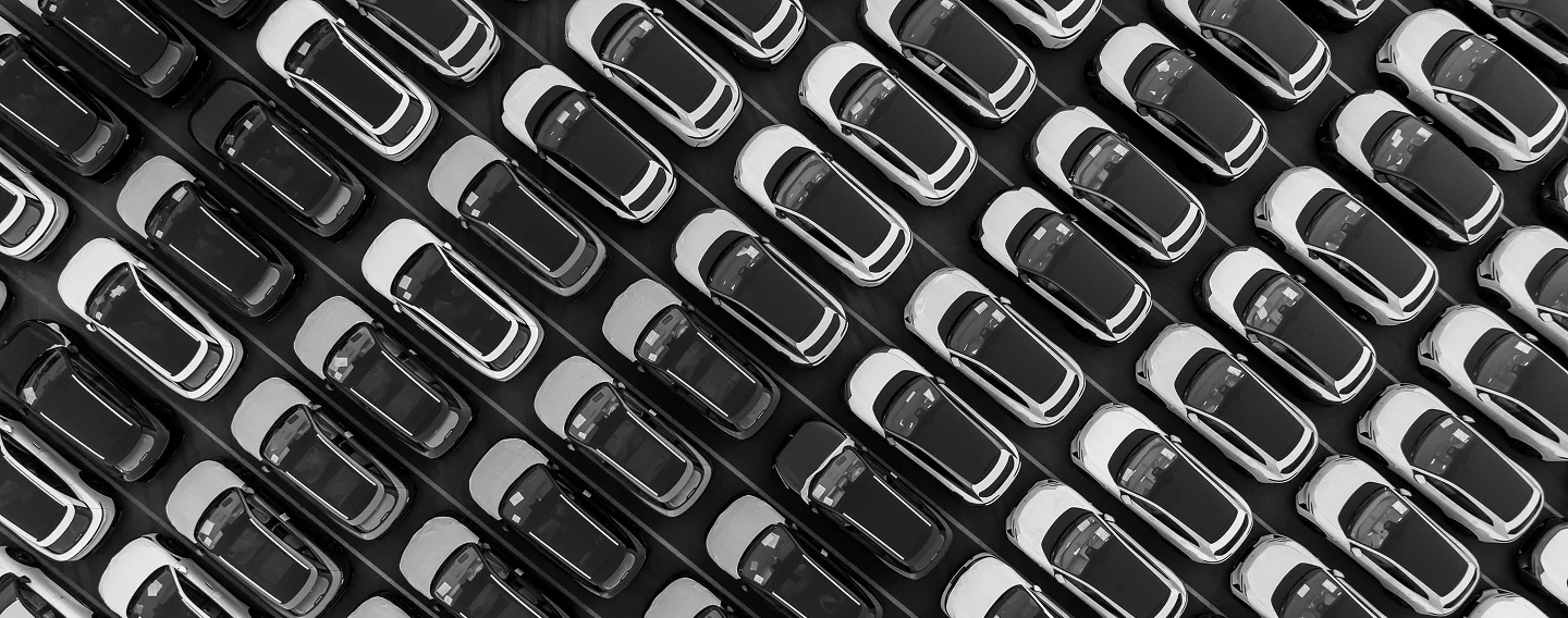 Rows of parked cars in a lot, viewed from above, illustrating automotive applications.