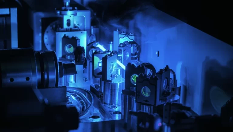 Advanced optical system with blue lighting, featuring intricate components and mirrors, related to quantum computing technology.