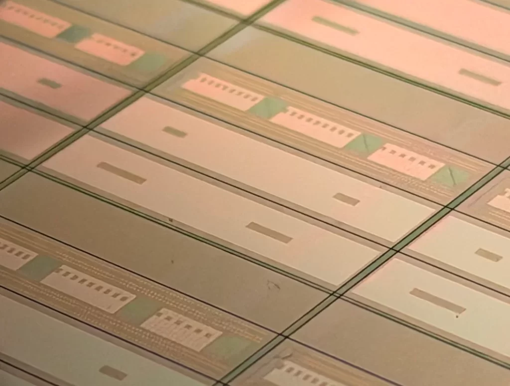 Close-up of semiconductor wafers with intricate circuit patterns, highlighting SkyWater Technology's role in quantum computing hardware development.