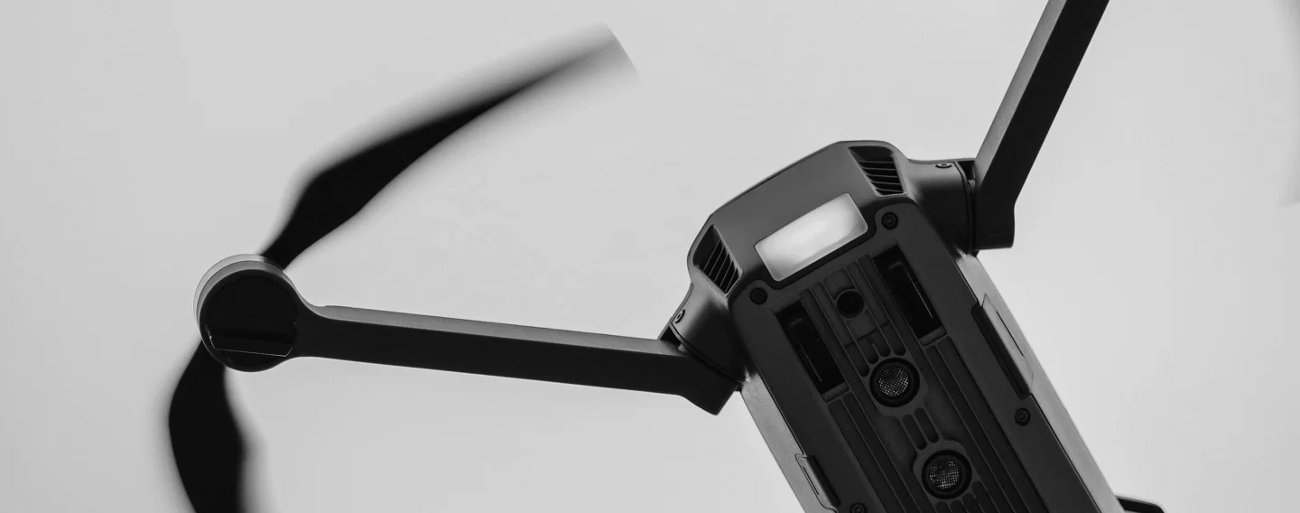 Drone in flight with spinning propellers, highlighting its relevance to aerospace and defense technology.