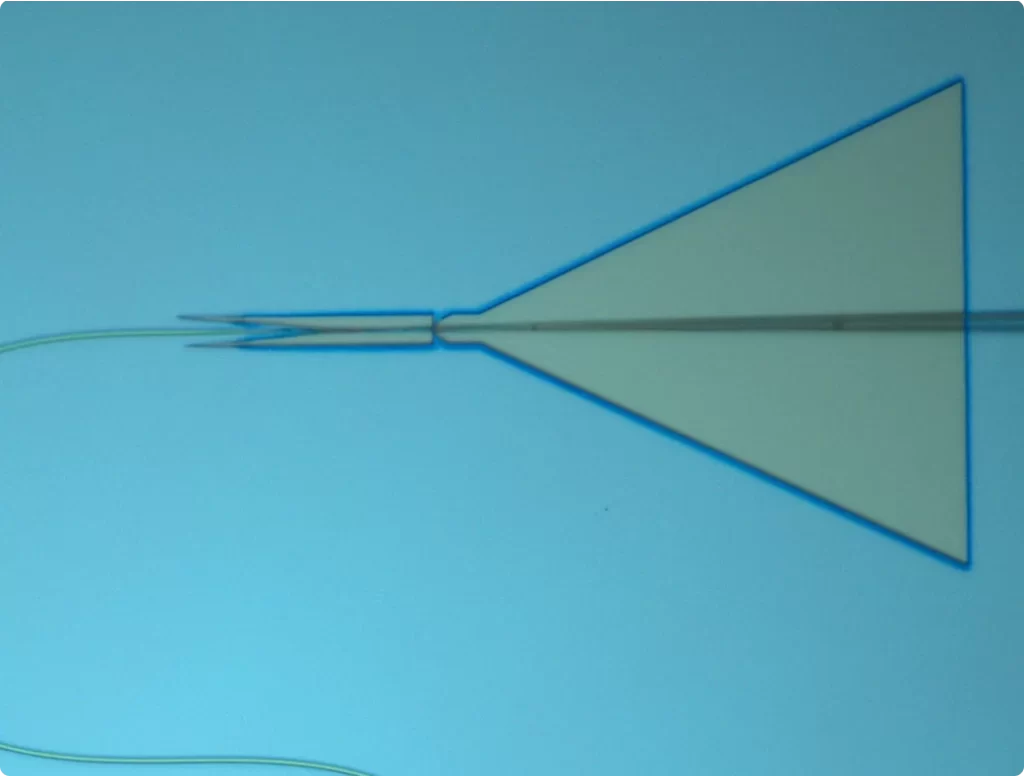Abstract geometric shape resembling a stylized arrowhead on a light blue background, possibly representing technological or quantum concepts.